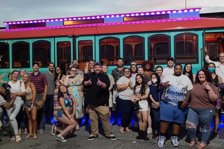 a group of people standing in front of a bus